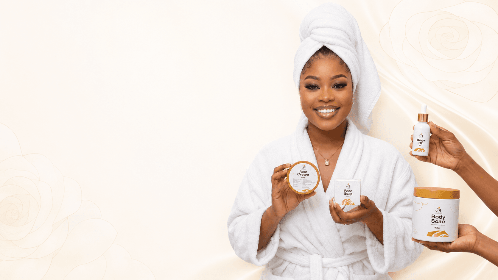 VEL model in a white robe presenting Face Cream and Face Soap with Body Oil and Body Soap